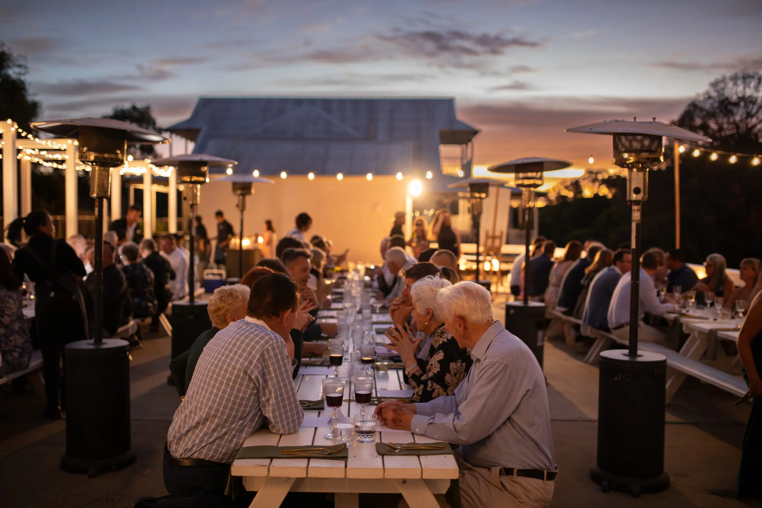 People sitting at a long table outside